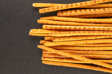 Straw is a bakery product. A few straws on a slate stone, macro, top view.