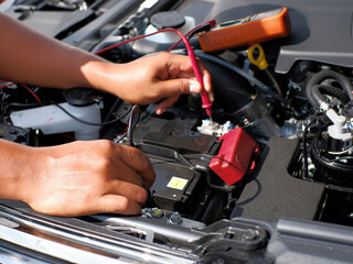 The mechanic checks the condition of the car battery life by using the battery voltage or multitester