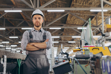 Factory male bearded worker is programming a CNC milling machine with copy space.