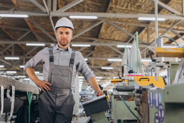 Fototapeta premium Factory male bearded worker is programming a CNC milling machine with copy space.