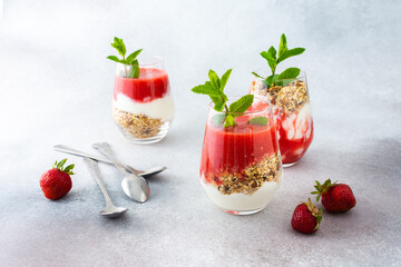 Healthy tasty breakfasts, glasses with granola and yogurt and strawberry smoothie