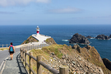 Una turista se dirige al faro del cabo Ortigal, en la costa gallega de La Coruña, España. © time and light