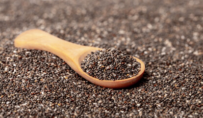 Chia seeds close-up with a wooden spoon. Chia seeds macro. Dry healthy supplement for proper nutrition.