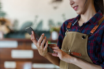 Close-up hand of beautiful asian woman standing holding tablet in hand. Used to check the inventory...