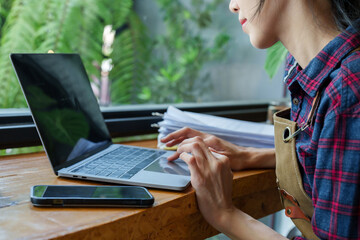 Close-up hand holding mobile phone closing screen lock laying on table, then put hand on keyboards laptop computer, typing on laptop computer, before closing cafe check income, expenses profits.