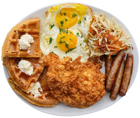 chicken and waffles breakfast meal sausage links, hash-browns, and sunny side up eggs on transparent background shot from overhead view
