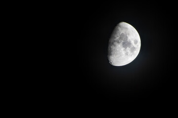 Half moon during the first quarter phase isolated against a black sky