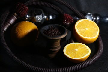 bowl with tobacco for hookah. shisha smoking. berries and fruits on a black background.