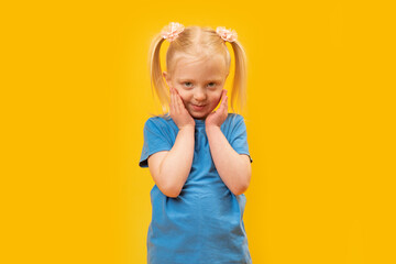 Portrait of shy preschool girl with two ponytails. Blonde child girl of 4-5 years old in blue...