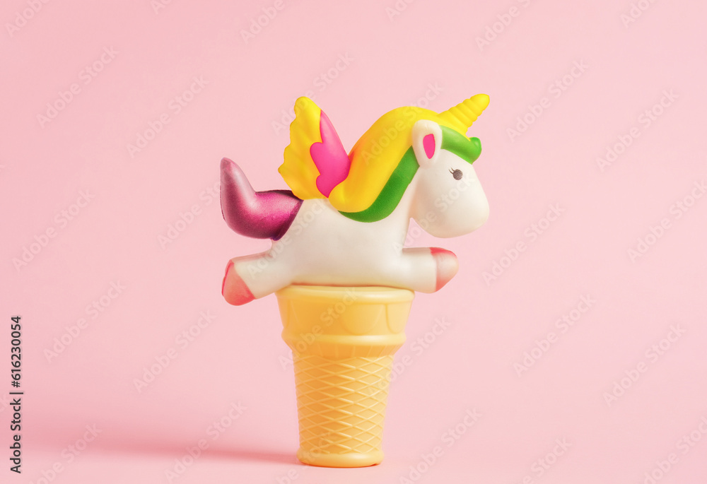 Wall mural Waffle cone with unicorn shape ice cream on pink background. Minimal art poster.