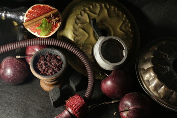 bowl with tobacco for hookah. nargile smoking. berries and fruits on a black background.