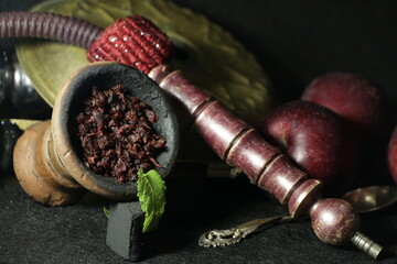 bowl of tobacco for hookah. smoking nargile. berries and fruits on a dark background