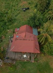 Aerial drone view of lush green island scenery with a single house at Tinggi Island or Pulau Tinggi in Mersing, Johor, Malaysia