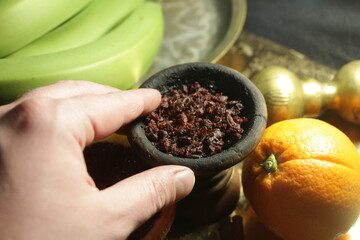 bowl of tobacco for hookah. smoking shiisha. berries and fruits on a dark background