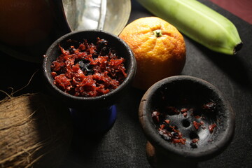 bowl with tobacco for hookah. nargile smoking. berries and fruits on a dark background.