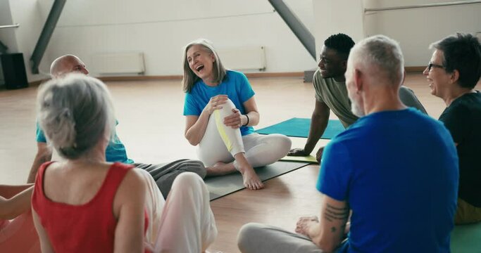 Group of mature friends laughing from funny stories after yoga