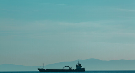 A commercial ship traveling in the Greek sea/ ocean.