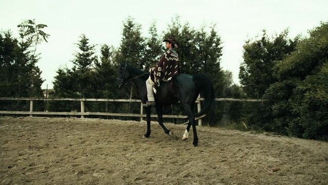 Riding a black horse in the ranch