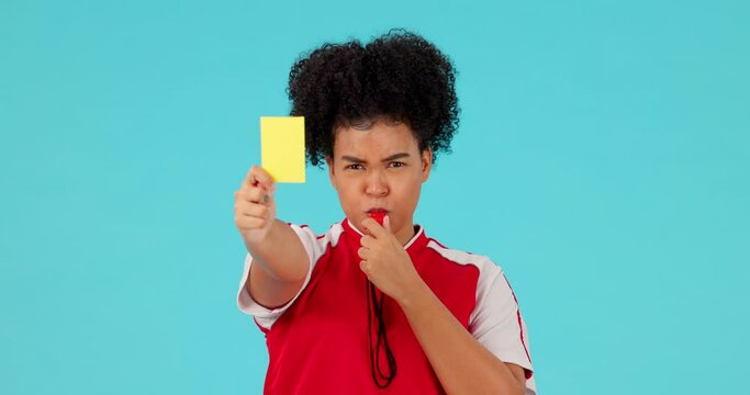 Whistle, yellow card and woman referee in a studio with rules for a football match, game or tournament. Sports, fitness and portrait of female soccer coach with equipment isolated by blue background.