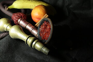 bowl with tobacco for hookah. nargile smoking. berries and fruits on a dark background.