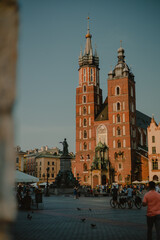 Fototapeta na wymiar View of Saint Mary Basilica in Krakow, Poland on a summer sunny day viewed from the arcades at main city square. Basilica in Krakow, Poland on a summer sunny day viewed from the arcades at square.
