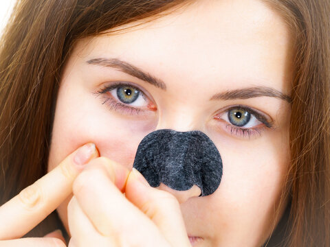 Woman Removing Pore Strips Mask From Nose