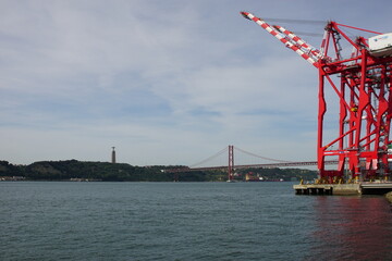 Bridge over River Tagus with Statue of Christ the King (Cristo Rei) with arms open to the City of Lisbon, Portugal