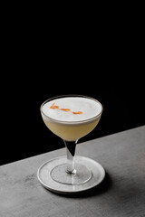 Pisco Sour a delicious cocktail served in a coupe glass on a bar table with a dark background