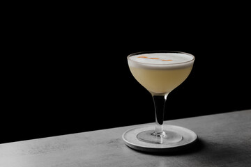 Pisco Sour a delicious cocktail served in a coupe glass on a bar table with a dark background