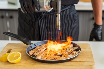 Japanese Chef using fire on salmon meat. Japanese Cuisine food, using gas burner torch.