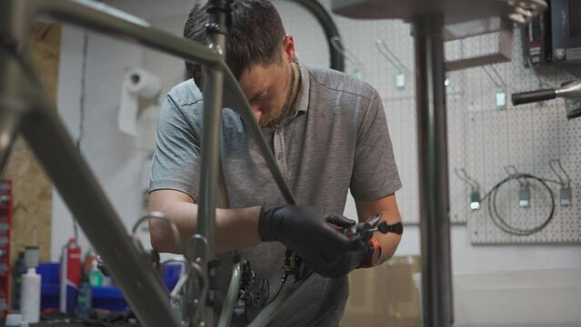 Bicycle mechanic holding syringe with brake fluid during brake bleeding process. Cycle repairman injects brake fluid into hydraulic brakes on bike in workshop. Maintenance cycle brake disc system. 