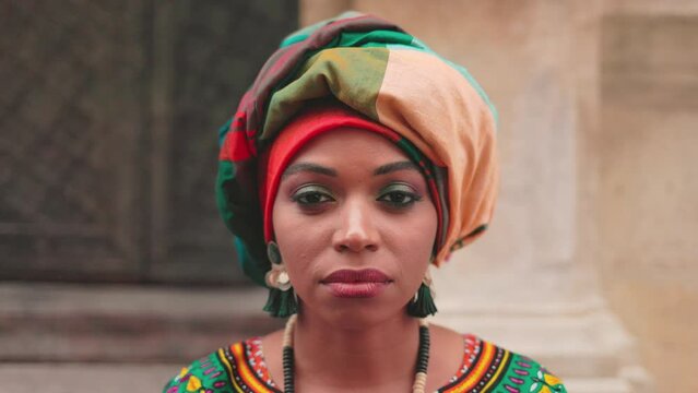 Close up half portrait of African woman. Multicultural female with make up and turban. Detailed image of multiethnic woman in bright jewelry. Serious woman dressed up in traditional costume.