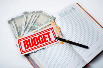 Budget Planning: Notepad with Money and Pen on White Background
