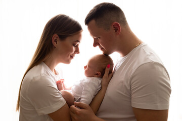 young parents hold the baby in their arms. family lifestyle photo with baby. family concept. family photo on white background
