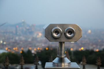Coin-operated binoculars looking out over city ,