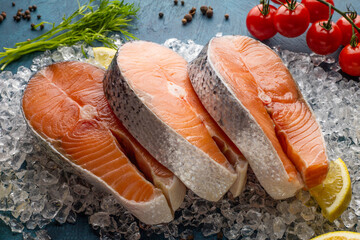 Fresh red fish steaks on ice with ingredients 