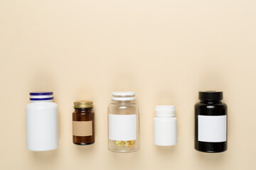 Plastic bottles with vitamins on color background, top view