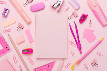Pink school stationery with notebook on color backgroung, top view