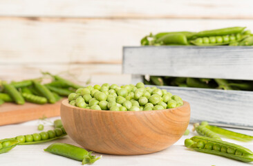 Composition with fresh green peas on wooden table