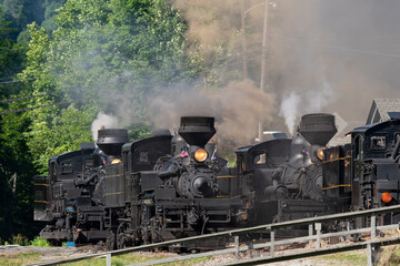 View of a Parade of Vintage Antique Shay Steam Locomotives Blowing Lots of Steam and Smoke as They Slowly Approach, on a Sunny Summer Day