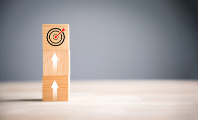 Target icon placed on cube wood blocks with upward arrows, symbolizing growth. Bar graph chart steps vertical style of a business growth process, profit, investment, economic improvement concepts.