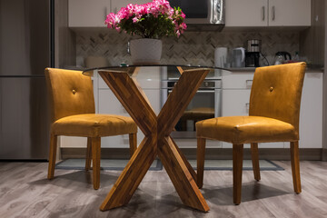 Fototapeta na wymiar Modern kitchen interior with yellow furniture. Cozy well designed modern kitchen interior with dining table and chairs
