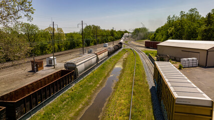 An Aerial View of a Steam Locomotive Moving Freight Cars Around in a Freight Yard to Organize a Freight Train on a Sunny Day