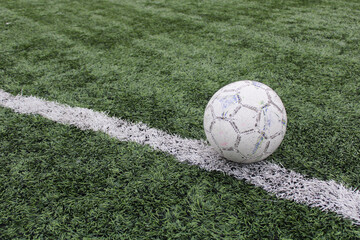 Fototapeta na wymiar white soccer ball on the grass. soccer field and white line.