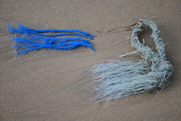 Two frayed ropes in the sand for attaching boats at the beach of Phuket-Thailand.
