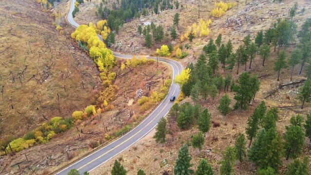 Solo car driving into the mountains of Colorado during fall season