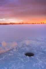 Gardinen Ice fishing on a frozen lake at Sunrise © rondakimbrow