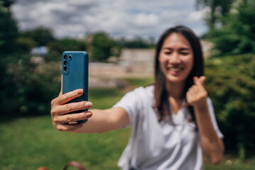 Young Japanese woman blogging in the public
