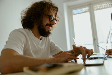 Smiling man freelancer sitting at home and working on laptop online. Remote work concept