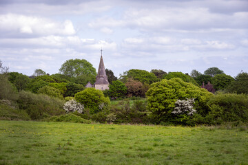 Fototapeta na wymiar Arlington church nestled in the trees in spring, Wealden, East Sussex, England